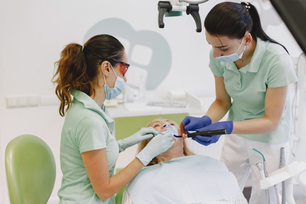 Dentist applying a protective dental sealant to a patient's molar during a routine preventive dental visit to help reduce the risk of cavities.