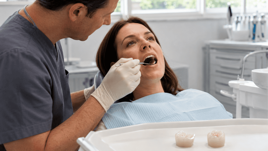 Dentist examining a patient’s back tooth with partial onlay and full crown options displayed nearby.